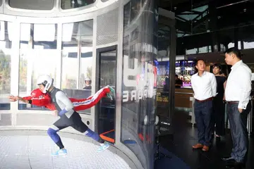 TINGKAT KECEKAPAN: Pelan Digital Industri Pelancongan dilancarkan pada Selasa di iFly Singapore, yang dihadiri oleh (dari kanan, berdiri) Ketua Pegawai Eksekutif iFly Singapore, Encik Lawrence Koh, dan Menteri Negara Kanan (Perhubungan dan Penerangan), Encik Tan Kiat How.