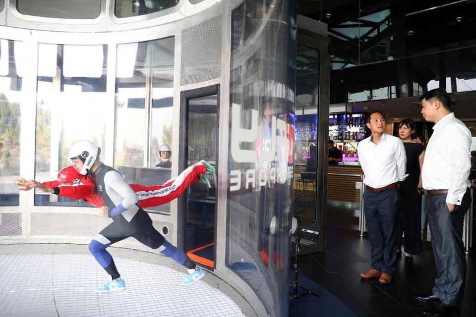 TINGKAT KECEKAPAN: Pelan Digital Industri Pelancongan dilancarkan pada Selasa di iFly Singapore, yang dihadiri oleh (dari kanan, berdiri) Ketua Pegawai Eksekutif iFly Singapore, Encik Lawrence Koh, dan Menteri Negara Kanan (Perhubungan dan Penerangan), Encik Tan Kiat How.