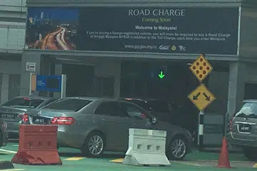 PELAKSANAAN VEP: Papan tanda peringatan ditempatkan di lorong masuk pemeriksaan kereta di Johor bagi mengingatkan kenderaan asing levi RM20 ($6.60) akan dikenakan tidak lama lagi. - Foto fail