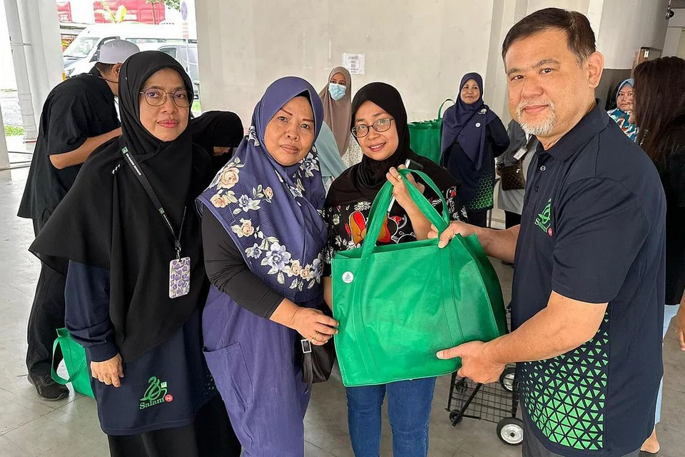AGIHAN DIHARGAI: Cik Marsitah (dua dari kanan) menghargai sumbangan yang diterimanya daripada Encik Jeffrey Low (kanan), Ustazah Sarima Jantan (kiri) dan sukarelawan, Cik Saidah Ismail (dua dari kiri). - Foto MASJID EN-NAEEM