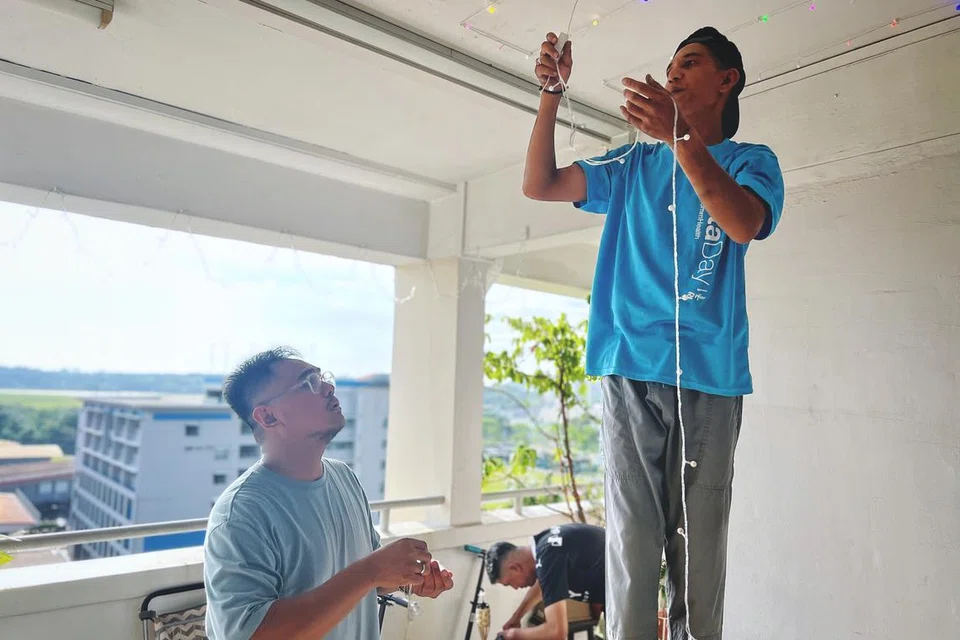 Encik Syahril (kiri), bersama jirannya Encik Farid Difari memasang lampu lap-lip