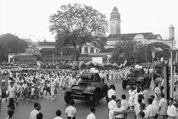 1960: Orang ramai menyaksikan perarakan kereta kebal di luar City Hall.