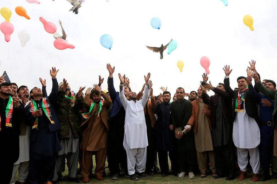 RAIKAN PERJANJIAN DAMAI: Rakyat Afghanistan meraikan perjanjian damai yang ditanda tangani antara Amerika dengan Taleban, yang boleh mendatangkan keamanan kepada negara Asia itu. - Foto REUTERS