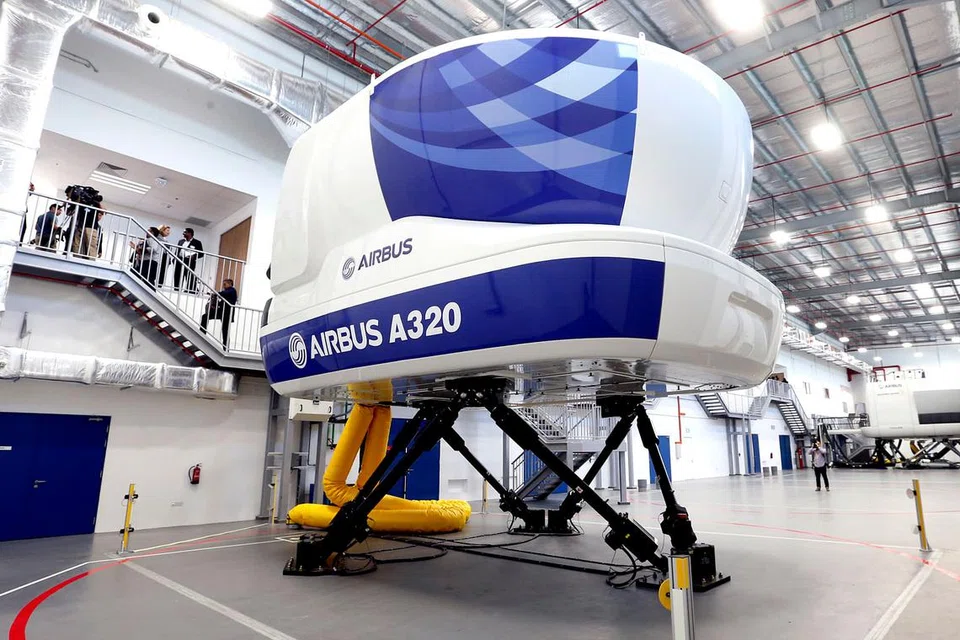 SIMULATOR CANGGIH: Tetamu memasuki simulator penerbangan semasa melawat Pusat Latihan Airbus Asia kelmarin. - Foto THE STRAITS TIMES