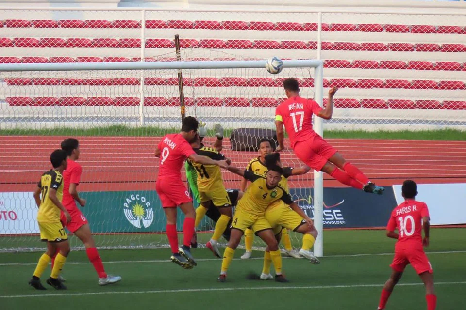 Irfan (jersi 17) cuba menanduk masuk bola ke dalam gawang lawan dalam kemenangan 7-0 Singapura ke atas Brunei di Stadium Memorial Rizal semalam. - Foto ZULAIQAH ABDUL RAHIM