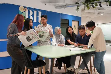 Tenaga kerja Berita Harian (BH) meneliti akhbar BH yang berwajah baharu dan bersaiz kompak.