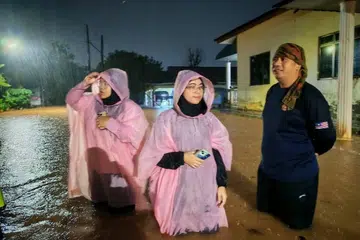 Calon Parti Ikatan Demokratik Malaysia (Muda) bagi kerusi Dewan Undangan Negeri (DUN) Puteri Wangsa, Cik Rashifa Aljunied (tengah), semasa kejadian banjir pada Mac 2025.
