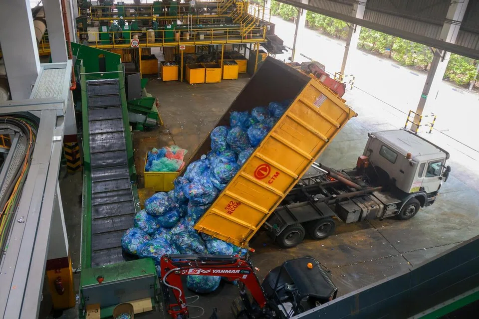 Sebuah kenderaan sedang memunggah beg-beg yang mengandungi bekas minuman di Kemudahan Pengiraan dan Pengisihan di Tuas.