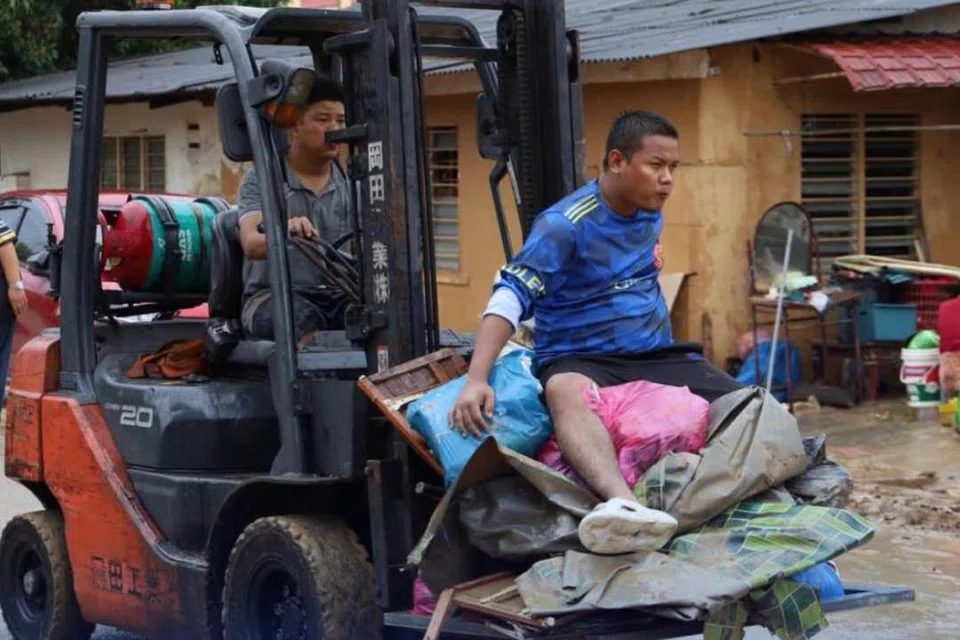 Penduduk menggunakan jentera berat untuk memindahkan barangan yang rosak selepas kediaman mereka ditenggelami banjir antara yang paling buruk di Johor pada 20 Mac lalu.