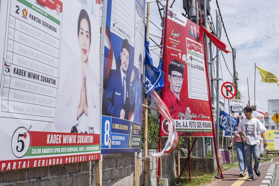 HANGAT BERKEMPEN: Petugas pilihan raya membawa bendera 18 parti politik yang bertanding dalam pilihan raya umum 2024 semasa upacara di sepanjang Jalan Denpasar Bali.