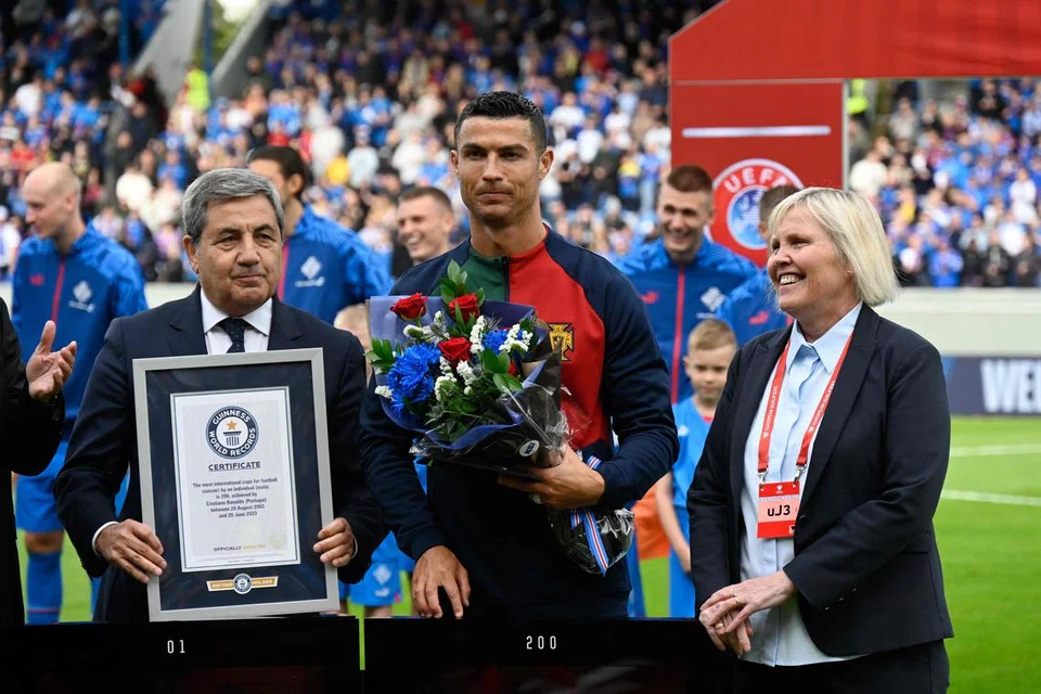 REKOD DUNIA: Cristiano Ronaldo (tengah) menerima sijil Rekod Dunia Guinness sebelum perlawanan antara Portugal dengan Iceland. Beliau memahat namanya dalam rekod dunia sebagai pemain bola sepak yang paling banyak kali mewakili negaraya iaitu 200 kali.