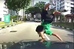 AKIBAT TIDAK BERWASPADA: Walaupun tercampak di depan kereta yang melanggarnya, budak yang meluru di depan sebuah bas di Jurong West Street 81 ini tidak mengalami kecederaan serius. - Foto FACEBOOK/ROADS.SG