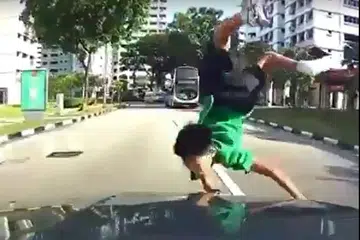 AKIBAT TIDAK BERWASPADA: Walaupun tercampak di depan kereta yang melanggarnya, budak yang meluru di depan sebuah bas di Jurong West Street 81 ini tidak mengalami kecederaan serius. - Foto FACEBOOK/ROADS.SG
