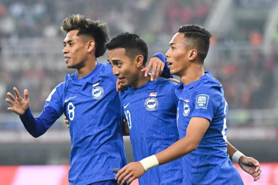Faris Ramli (tengah) meraikan golnya untuk Singapura bersama rakan sepasukan Shah Shahiran (kiri) dan Shawal Anuar. Gol itu membolehkan Singapura masuk ke waktu rehat dengan jaringan 1-1. 