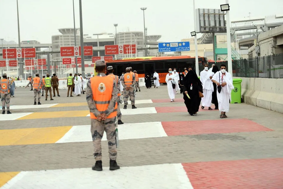 KAWALAN KETAT: Anggota pasukan keselamatan Arab Saudi berkawal sedang para jemaah yang berpelitup memasuki kawasan suci Makkah bagi menunaikan ibadah haji. - Foto EPA-EFE 