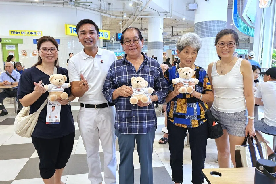 Profesor Madya Elmie Nekmat (dua dari kiri) mengedarkan patung beruang PAP GRC Sengkang kepada penduduk pada 30 Mac di Pusat Penjaja Buangkok yang terletak di Sengkang Grand Mall.