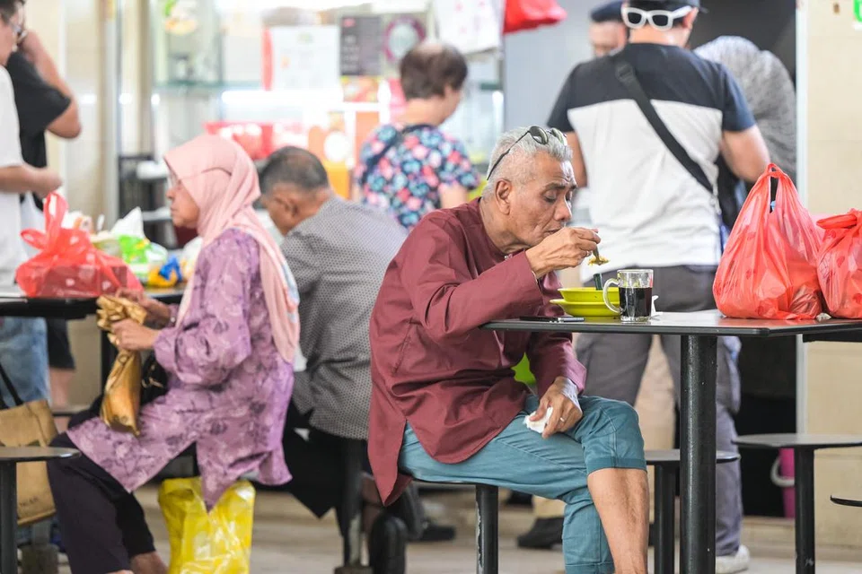 Pelanggan menikmati makanan di pusat penjaja yang terletak berdekatan pusat pertukaran bas Bedok.