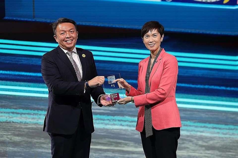 USAHA DISANJUNGI: Cik Josephine Teo menyampaikan anugerah Tempat Kerja Terbaik Singapura kepada Encik Christopher Ong, Naib Presiden Kanan merangkap Pengarah Urusan DHL Express Singapore. Syarikat itu menduduki tempat pertama dalam kategori tempat kerja besar dan sederhana. - Foto GREAT PLACE TO WORK INSTITUTE SINGAPORE