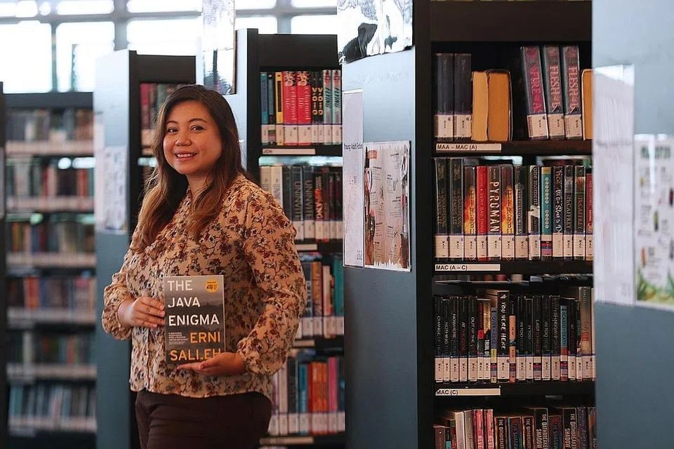 LEBIH DARI SEORANG PUSTAKAWAN: Pengurus Khidmat Perpustakaan Bergerak (Molly) di Lembaga Perpustakaan Nasional (NLB) Cik Erni Salleh bersama novel sulungnya, The Java Enigma, yang tersenarai antara tiga finalis Epigram Books Fiction Prize 2020 pada awal tahun ini. - Foto BH oleh TIMOTHY DAVID