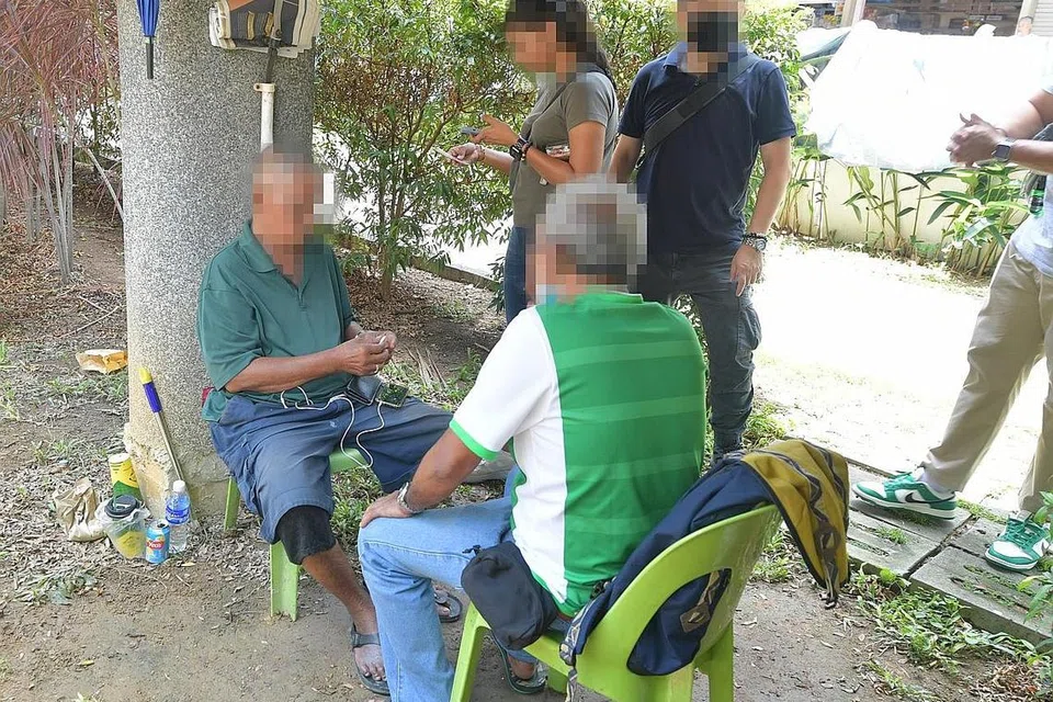 HISAP SEMBUNYI-SEMBUNYI: Dua warga emas kelihatan berteduh di bawah jejambat lalu lintas di Pasar Geylang Serai didapati memiliki beberapa batang rokok tidak dibayar cukai. - Foto-Foto BH oleh ALPHONSUS CHERN