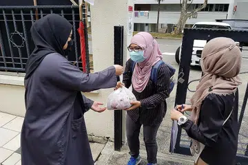 PRIHATIN: Petugas Masjid Al-Istiqamah (di kanan dan kiri, gambar atas) menyampaikan bungkusan kepada penerima agihan daging korban. - Foto MASJID AL-ISTIQAMAH