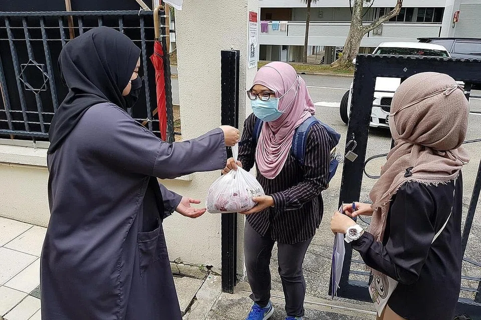 PRIHATIN: Petugas Masjid Al-Istiqamah (di kanan dan kiri, gambar atas) menyampaikan bungkusan kepada penerima agihan daging korban. - Foto MASJID AL-ISTIQAMAH
