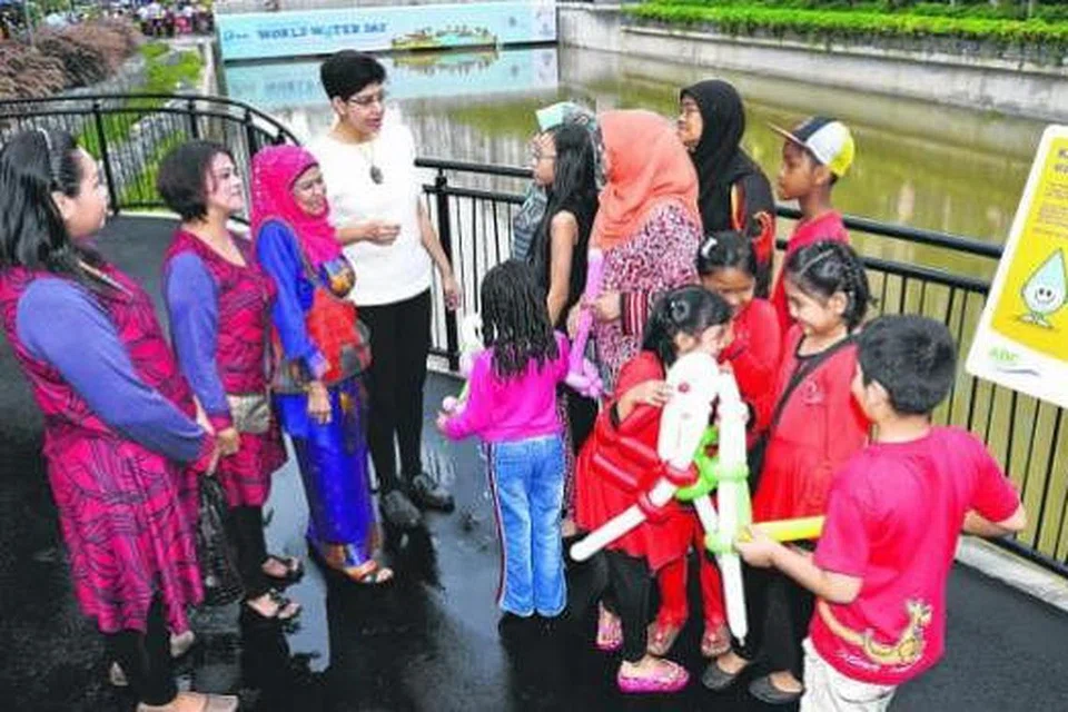 SATU KEBANGGAN: Dr Fatimah (baju putih) mengambil peluang menjelaskan tentang ciri estetika Melayu di Sungai Geylang kepada para penduduk semasa majlis pembukaan sungai tersebut semalam. - Foto M.O.SALLEH