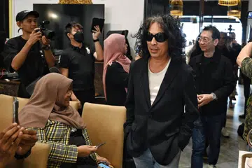AURA LEGENDA ROK: Datuk Amy Search (berkaca mata hitam), diikuti dengan gitaris utama Search, Hillary Ang (di belakang), memasuki ruang Restoran Permata di mana sidang media diadakan pada 14 Disember