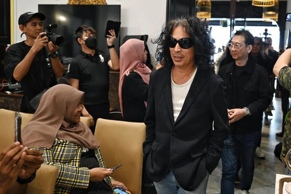 AURA LEGENDA ROK: Datuk Amy Search (berkaca mata hitam), diikuti dengan gitaris utama Search, Hillary Ang (di belakang), memasuki ruang Restoran Permata di mana sidang media diadakan pada 14 Disember