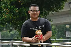 Sukarelawan Encik Saifudin Arif menerima Anugerah Belia Inspirasi atas usaha lebih sedekadnya berbakti kepada masyarakat. Beliau bergambar bersama patung yang diterimanya ketika berdamping dengan warga emas, yang masih disimpannya sebagai kenangan daripada perjalanan sukarelanya.
