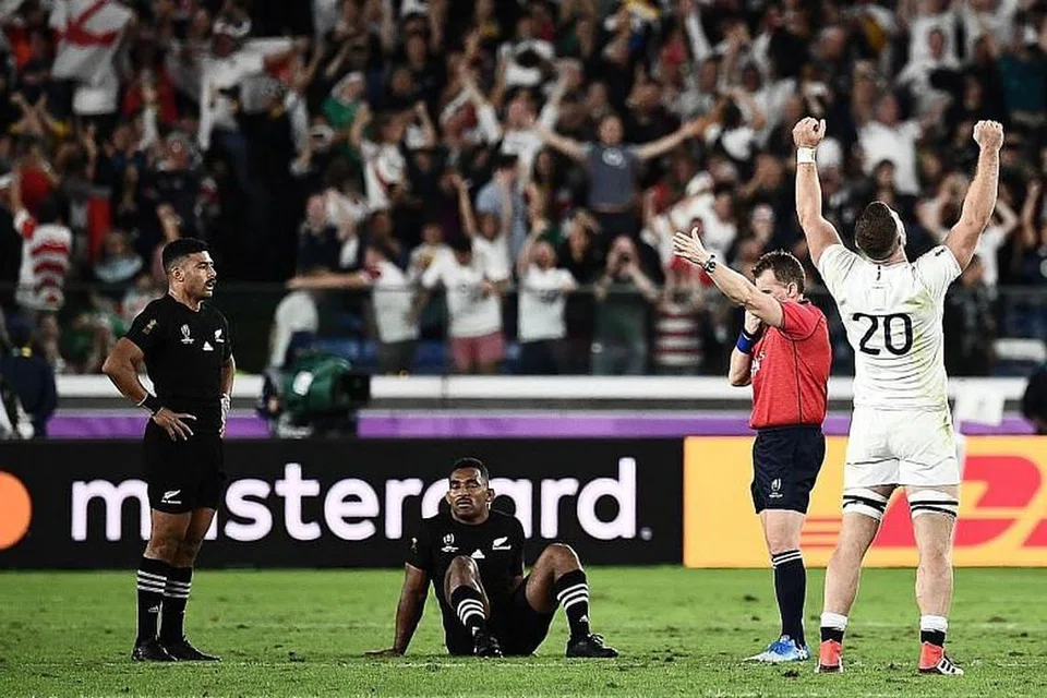 ALL BLACKS TEWAS: Pemain 'back row' England, Mark Wilson, (No. 20) meraikan kemenangan pasukannya sementara pemain 'fly-half' New Zealand, Richie Mo'unga (kiri) dan pemain 'wing' Sevu Reece kelihatan kecewa selepas ditewaskan dalam perlawanan separuh akhir Piala Dunia Ragbi di Stadium Antarabangsa Yokohama semalam. -Foto AFP. 