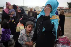 MENYAYAT HATI: Seorang wanita bersama anaknya dalam kepiluan semasa disambut saudara mara pada 11 April lalu, setelah suami dan anak-anak lelakinya mati dibunuh oleh kumpulan pengganas Negara Islam (IS), sewaktu mereka cuba melarikan diri dari kediaman mereka di kejiranan Sekak di barat Mosul. Keupayaan wanita itu dan anaknya untuk keluar dari kawasan yang ditadbir IS itu diselia oleh pasukan perangi terorisme Iraq (CTS), yang berusaha menawan semula bandar itu daripada IS. - Foto AFP
