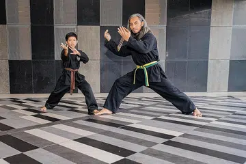 CARA DORONG ANAK: Apabila diajak turut belajar bersilat, Encik Muhammad Fazely melihat peluang itu sebagai cara menjadikan anaknya, Muhammad Syah Adam, lebih terdorong berlatih. Kini beliau, isteri dan anak kedua mereka turut belajar silat di tempat yang sama, dengan beliau membantu jurulatih mengajar. - Foto BH oleh NUR DIYANA TAHA
