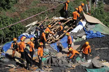 Pegawai bomba Korea Selatan mencari mangsa yang hilang di kawasan yang dilanda tanah runtuh di Busan, Korea Selatan. - Foto EPA-EFE