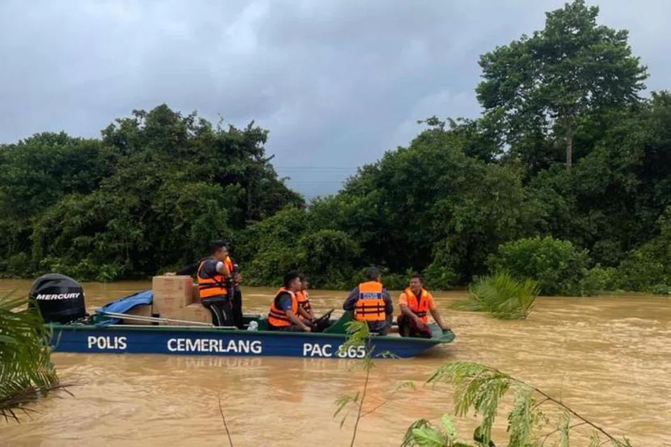 REDAH BANJIR: Anggota polis dari Ibu Pejabat Polis Daerah Kuantan, Pahang, meredah banjir untuk masuk ke kawasan terjejas banjir bagi membantu operasi memindahkan mangsa pada 25 Januari.