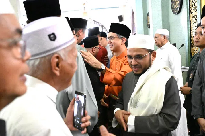 Pemangku Menteri Bertanggungjawab bagi Ehwal Masyarakat Islam, Profesor Madya Dr Muhammad Faishal Ibrahim (dua dari kanan) dan Mufti Dr Nazirudin Mohd Nasir (paling kanan) beramah mesra dengan jemaah yang hadir selepas sesi pertama solat Aidilfitri di Masjid Sultan pada 21 Mac.