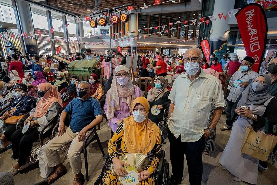 PERTAMA KALI DI SAMBUTAN HARI KEBANGSAAN: Encik Sapiee Sadi (depan, kanan), 70 tahun, bersama isterinya Cik Rokiah Hassan (depan, dua dari kanan), 70-an tahun, dan pembantu mereka, Cik Baidah Sri Mulyani (depan, tiga dari kanan), 47 tahun, dihiburkan dengan pelbagai persembahan di atas pentas WGS semalam.- Foto-foto BH oleh NUR DIYANA TAHA