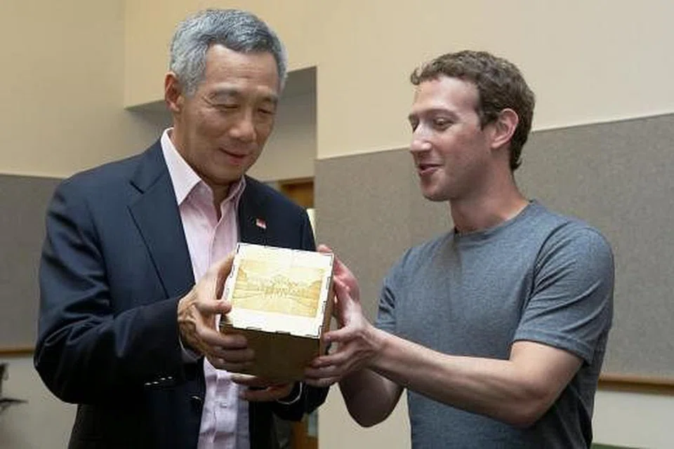 BUAT KENANG-KENANGAN: Encik Mark Zuckerberg menghadiahkan sebuah kiub kepada Encik Lee dengan goresan gambar-gambar daripada laman Facebook Encik Lee dan kod penyelesaian Sudoku yang ditulis Encik Lee. - Foto FACEBOOK PM LEE