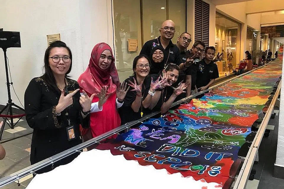 SUMBANG KEMBALI: Encik Kamal (empat dari kanan) dan Cik Ng (kiri) membuat keputusan mengadakan acara ini bagi menyumbang kembali kepada sekolah mereka, Nafa. - Foto FACEBOOK KAMAL DOLLAH