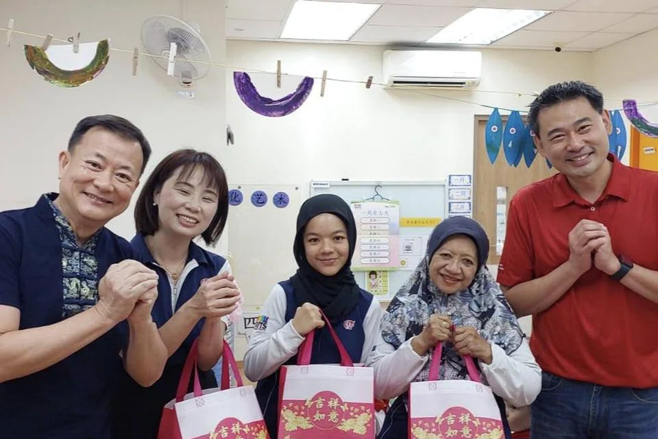 Pengerusi cawangan Bedok Reservoir-Punggol Parti Tindakan Rakyat (PAP), Encik Victor Lye (kiri) bersama naib pengerusi cawangan tersebut, Dr Adrian Ang (kanan) mengagih buah limau kepada kakitangan PCF Sparkletots pada 24 Januari.