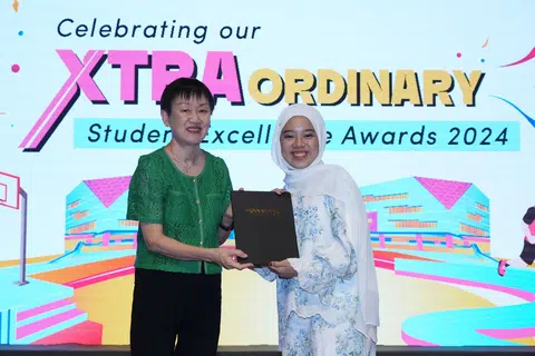 Cik Camelia Sephiana Nor Azmi (kanan), menerima Anugerah Pujian Khas: Khidmat Masyarakat daripada Politeknik Ngee Ann (NP) yang meraikan pencapaian ke-20 Anugerah Kecemerlangan Pelajar (SEA) pada 18 Julai, disampaikan oleh Pengarah Kanan Pelajar NP, Cik Tang-Lim Guek Im.