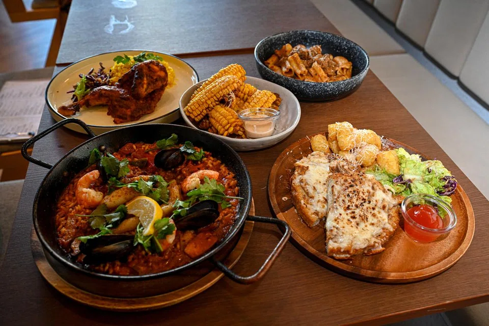 (Ikut putaran jam, dari kiri, bawah) Hidangan ‘Paella De Marisco’, Nasi Ayam Kuning, ‘Corn Ribs’, Pasta Rendang dan Roti John di Bruch @ Legundi. 