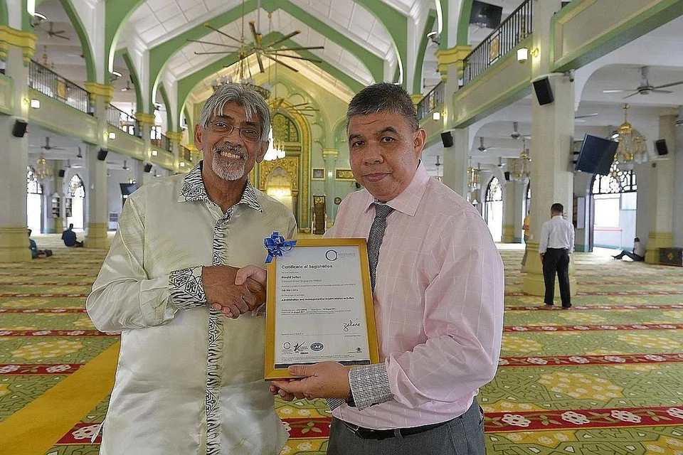 PENSIJILAN ISO 9001: Pengerusi Lembaga Pentadbir Masjid Sultan, Encik Mohamed Patail (kiri), menerima sijil ISO 9001 daripada Ketua Pensijilan ISO, Encik Zakaria Fadzil, di Masjid Sultan, yang merupakan masjid pertama di Singapura mendapatkan pengiktirafan tersebut. - Foto-foto TUKIMAN WARJI