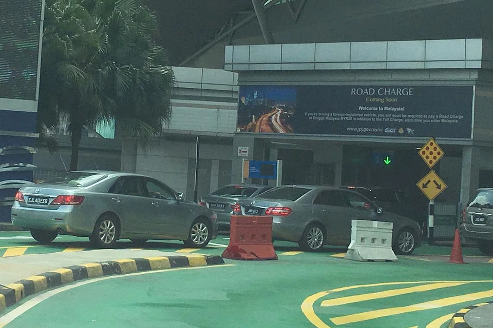 SISTEM VEP DIUJI: Papan tanda peringatan ditempatkan di lorong masuk pemeriksaan kereta di Johor bagi mengingatkan kenderaan asing mengenai bayaran levi RM20 ($6.60) yang akan dikenakan tidak lama lagi. - Foto HAKIM YUSOF