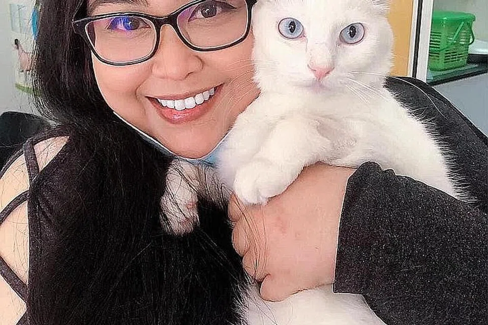 BERIKAN BANTUAN: Cik Nasha dengan seekor kucing putih bernama 'Shiro' yang jatuh dari tingkat sembilan kerana pemilik tidak memasang pengadang wayar di jeriji tingkap sekitar Mac lalu. Namun malangnya, kucing tersebut telah mati bulan lalu. - Foto ihsan NASHA 'FELINE' 