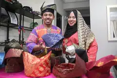 HIDUPKAN TANJAK: Encik Muhammad Fairuz Zazali, pengasas Tanjak Mahkota SG, yang kelihatan bersama adiknya, Cik Nur Farhanah, ingin melihat lebih ramai orang Melayu, terutama golongan muda, memakai tanjak, sambil hapuskan anggapan bahawa tanjak tidak layak dipakai oleh 'orang biasa'. - Foto BM oleh BENJAMIN SEETOR