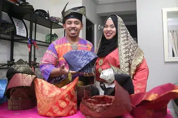 HIDUPKAN TANJAK: Encik Muhammad Fairuz Zazali, pengasas Tanjak Mahkota SG, yang kelihatan bersama adiknya, Cik Nur Farhanah, ingin melihat lebih ramai orang Melayu, terutama golongan muda, memakai tanjak, sambil hapuskan anggapan bahawa tanjak tidak layak dipakai oleh 'orang biasa'. - Foto BM oleh BENJAMIN SEETOR