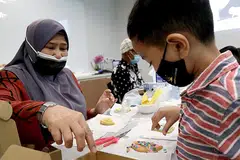 AKTIVITI ERATKAN HUBUNGAN: Antara aktiviti yang diadakan termasuk menghias biskut yang bertujuan untuk mengeratkan hubungan antara datuk, nenek dan cucu mereka. - Foto PPIS