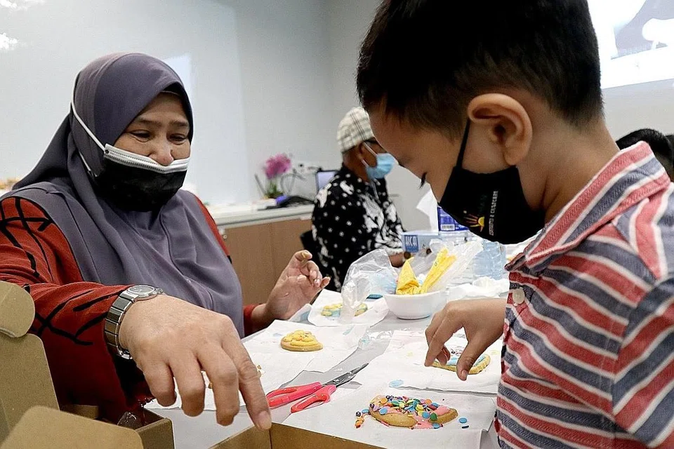 AKTIVITI ERATKAN HUBUNGAN: Antara aktiviti yang diadakan termasuk menghias biskut yang bertujuan untuk mengeratkan hubungan antara datuk, nenek dan cucu mereka. - Foto PPIS