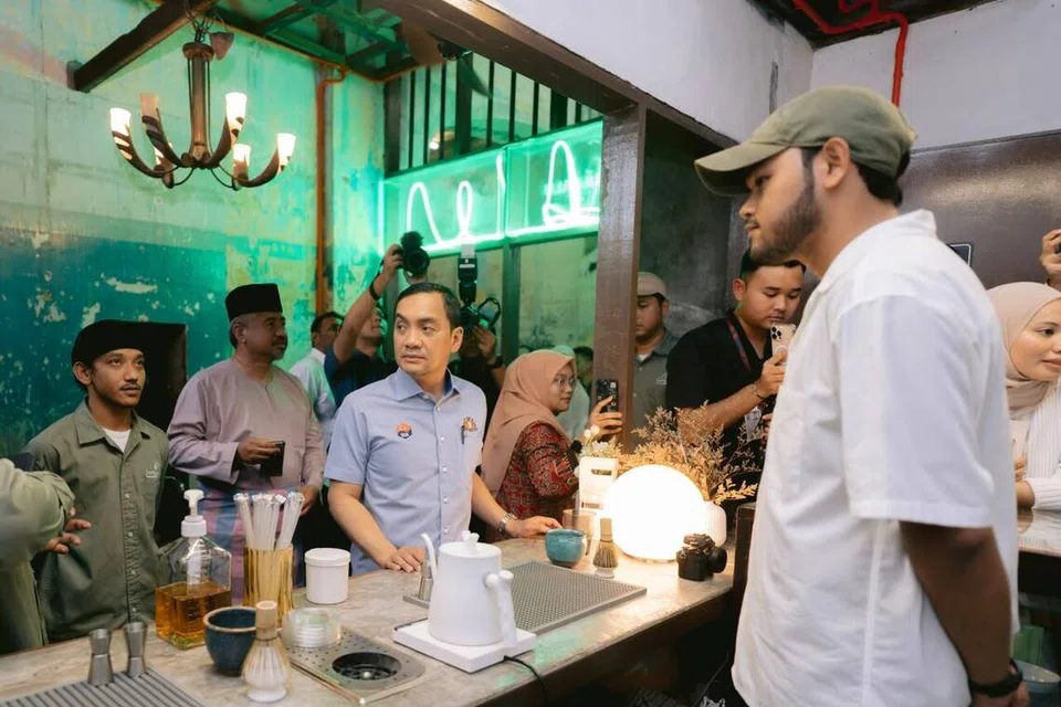 Pengasas Matcha Lalu, Encik Haziq Nor Azahar (kanan), ketika mengambil pesanan daripada Menteri Besar Johor, Datuk Onn Hafiz Ghazi (tengah).